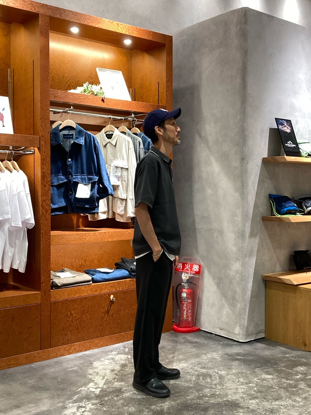 グレー系のポロシャツ、ブラック系のスラックス、ブルー系のキャップを着用したメンズの夏コーディネートの2枚目の写真