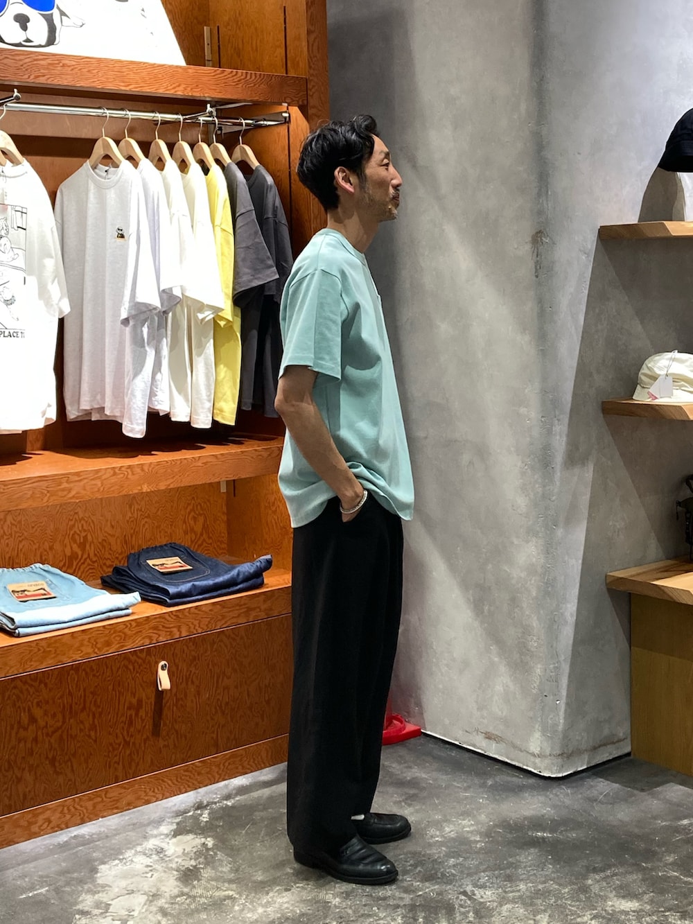 グリーン系のTシャツ/カットソー、ブラック系のスラックスを着用したメンズの夏コーディネートの2枚目の写真