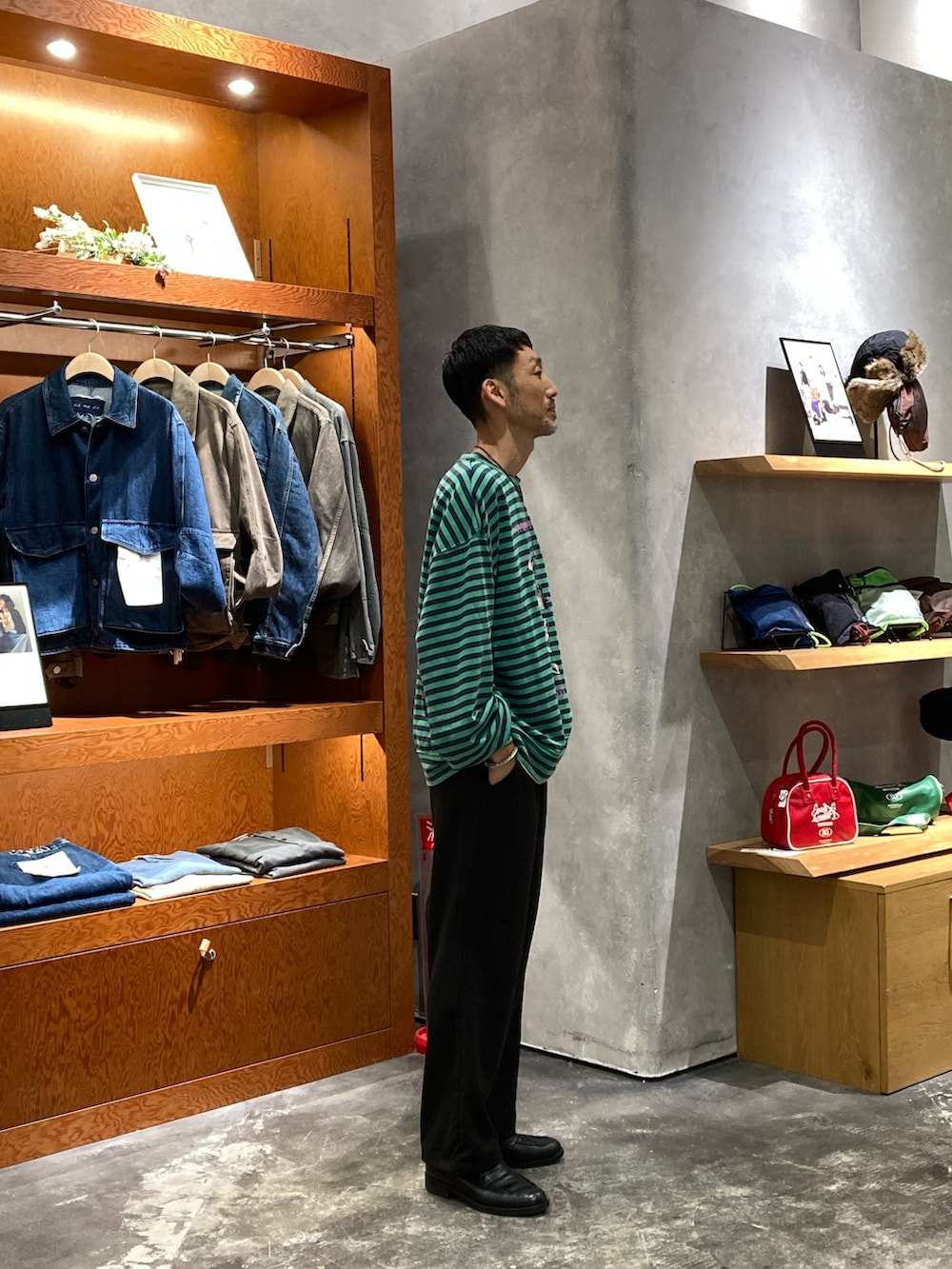 グリーン系のスウェット、ブラック系のスラックスを着用したメンズの秋コーディネートの2枚目の写真