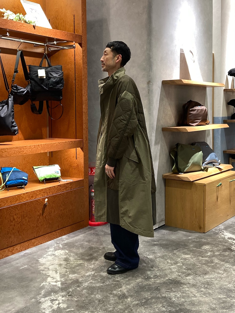 グリーン系のモッズコートを着用したメンズの冬コーディネートの2枚目の写真