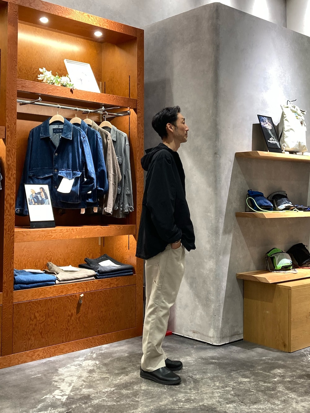 グレー系のデニムパンツ、ホワイト系のTシャツ/カットソー、ブラック系のマウンテンパーカーを着用したメンズの秋コーディネートの2枚目の写真