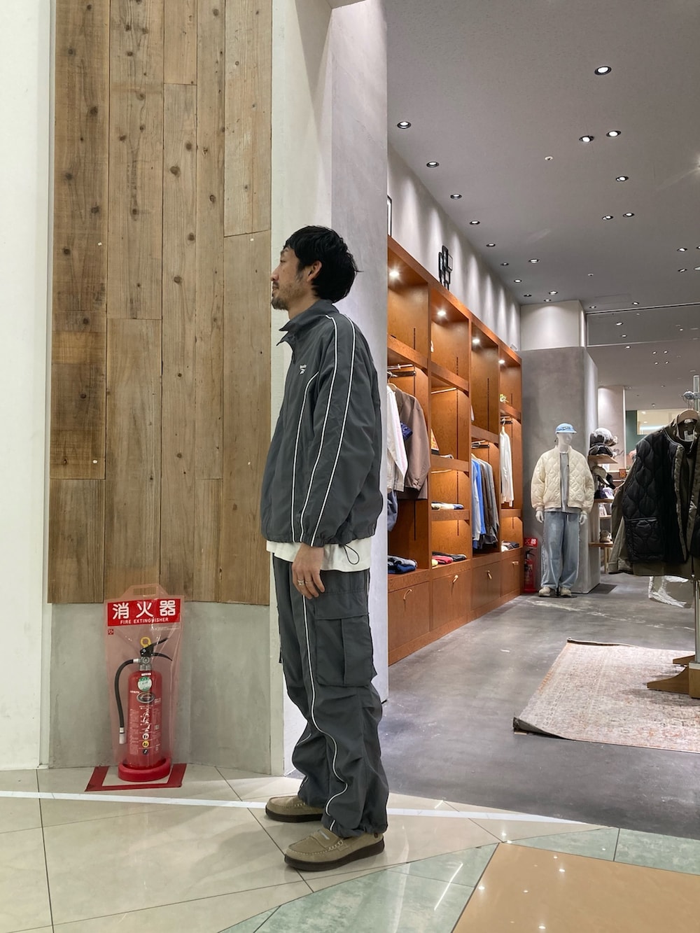 グレー系のナイロンジャケット、グレー系のカーゴパンツ、ホワイト系のTシャツ/カットソーを着用したメンズの春コーディネートの2枚目の写真