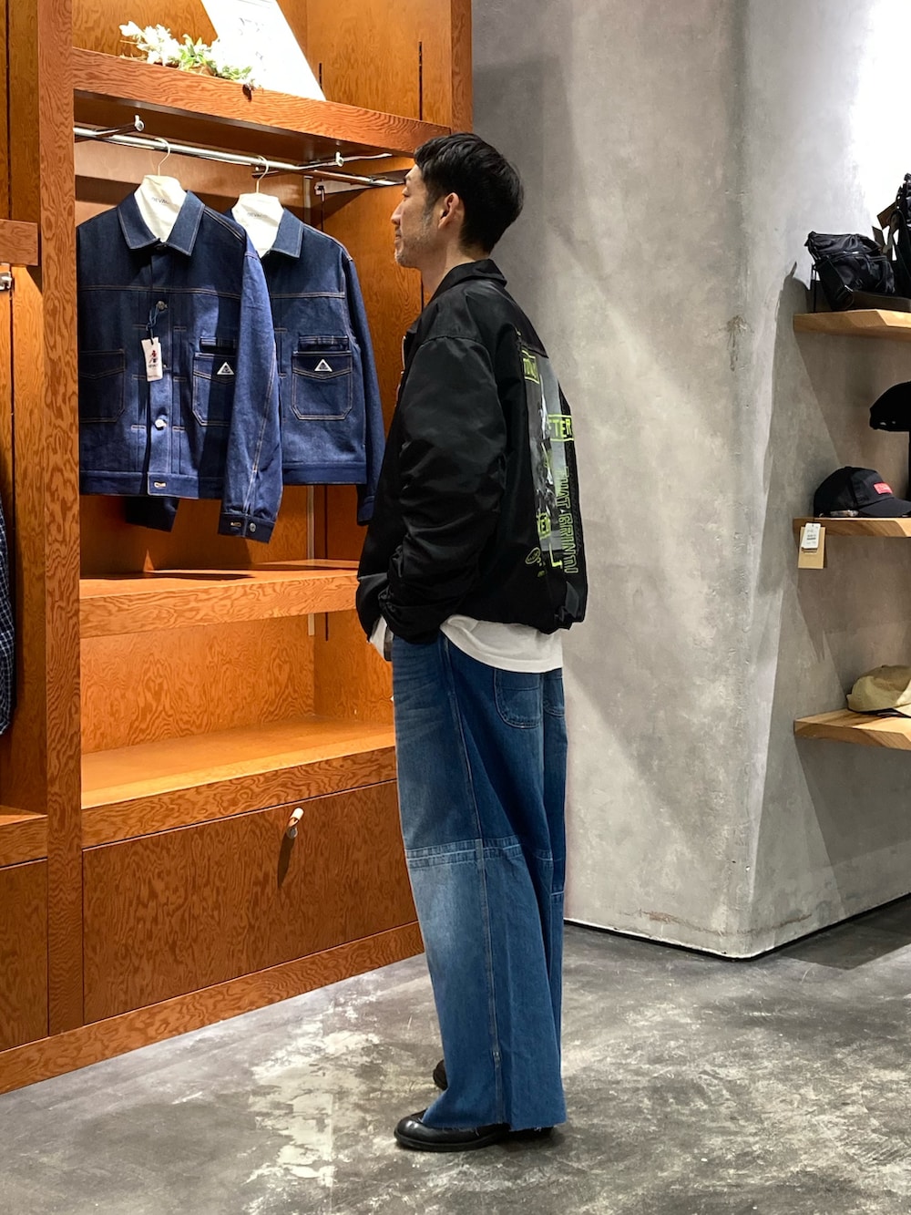 ブラック系のMA-1、ブルー系のデニムパンツを着用したメンズの春コーディネートの2枚目の写真