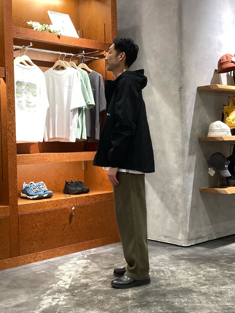 グレー系のTシャツ/カットソー、グリーン系のその他パンツ、ブラック系のマウンテンパーカーを着用したメンズの春コーディネートの2枚目の写真