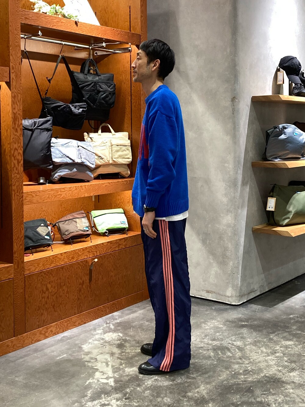 ブルー系のニット/セーター、ブルー系のスウェットパンツを着用したメンズの冬コーディネートの2枚目の写真