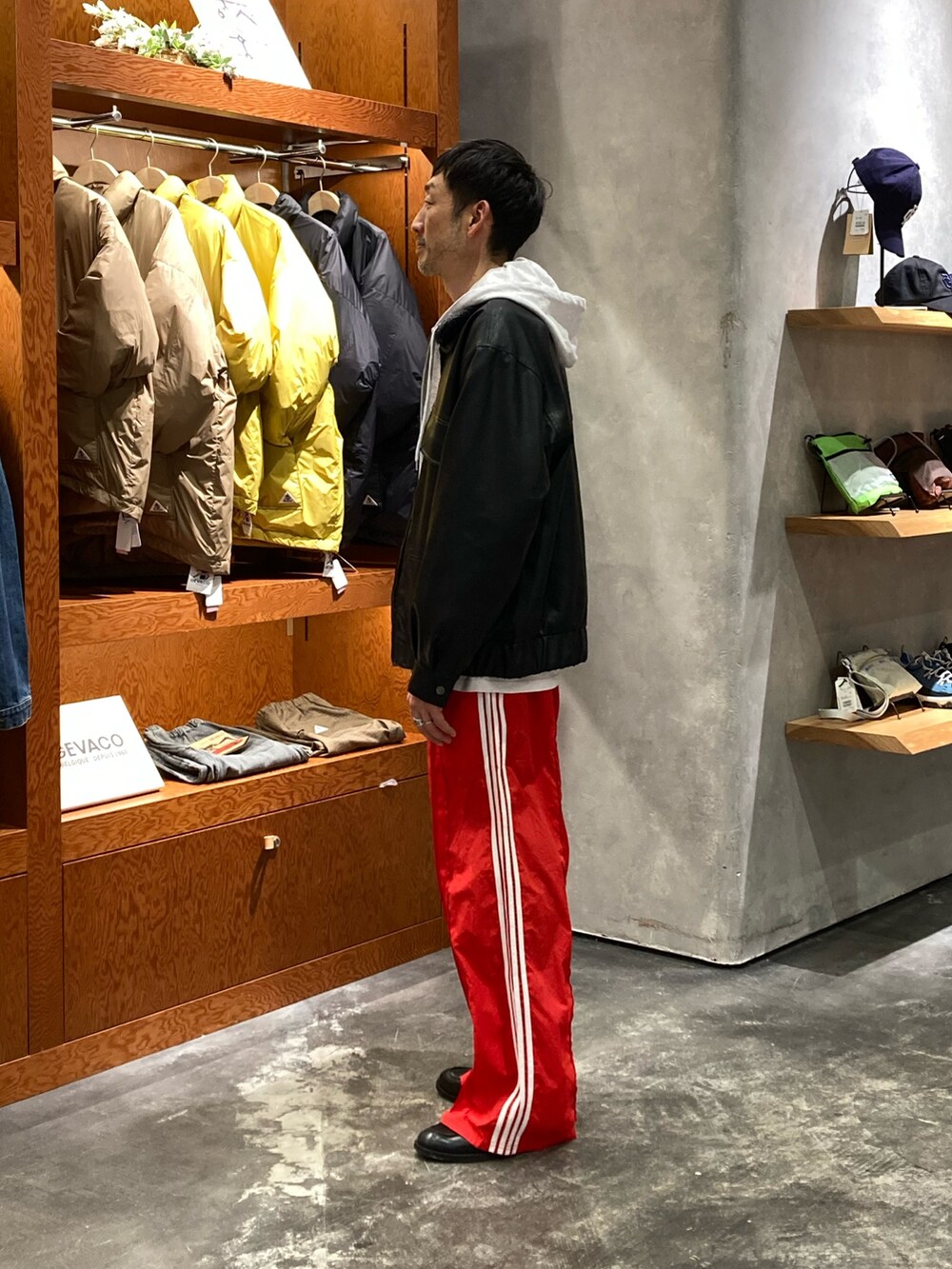 レッド系のスウェットパンツ、ブラック系のライダースジャケット、グレー系のパーカーを着用したメンズの冬コーディネートの2枚目の写真