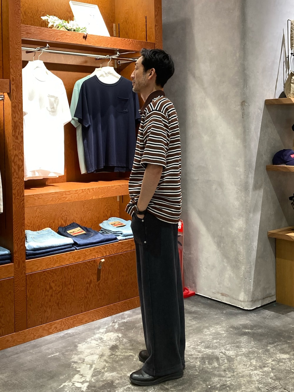 ブラック系のスウェットパンツ、ブラウン系のポロシャツを着用したメンズの夏コーディネートの2枚目の写真
