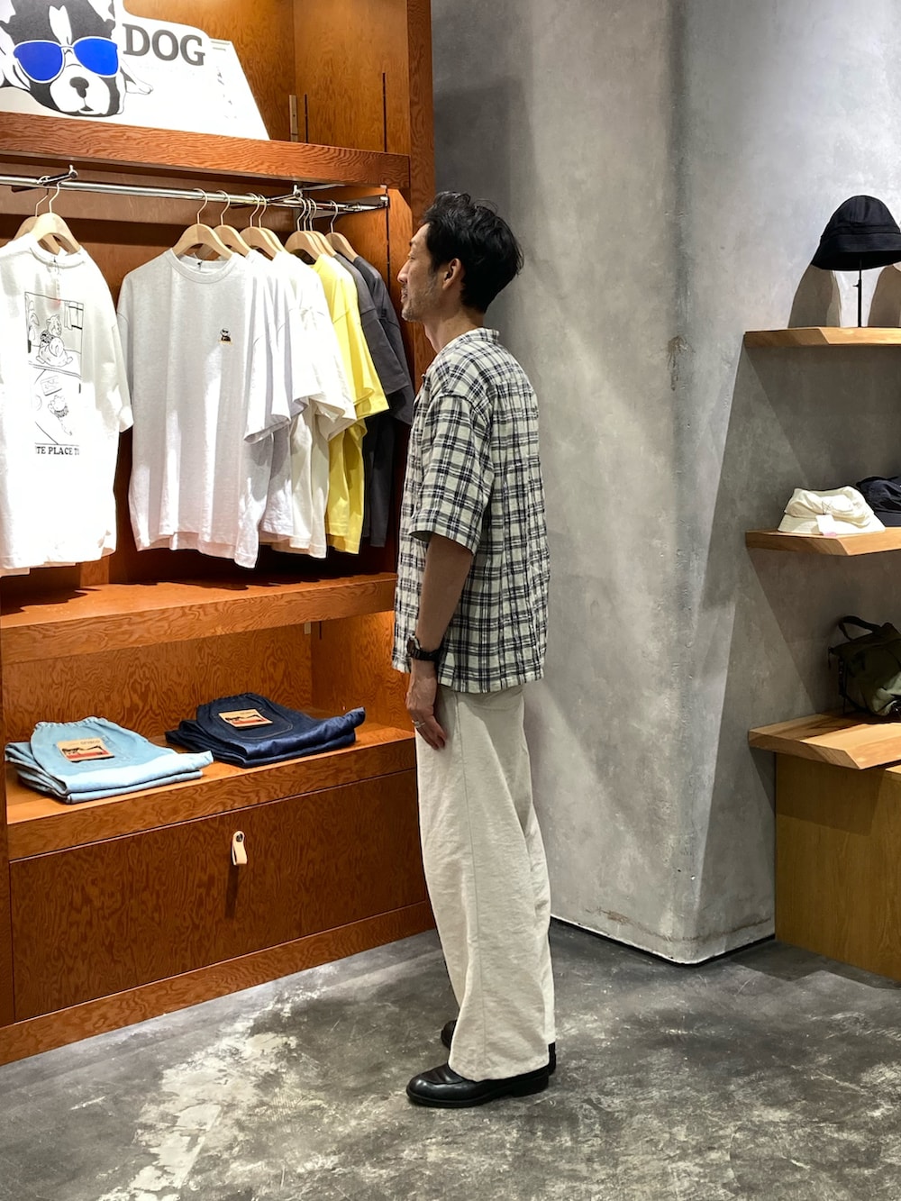 グレー系のタンクトップ、ホワイト系のスラックス、ベージュ系のシャツ/ブラウスを着用したメンズの夏コーディネートの2枚目の写真