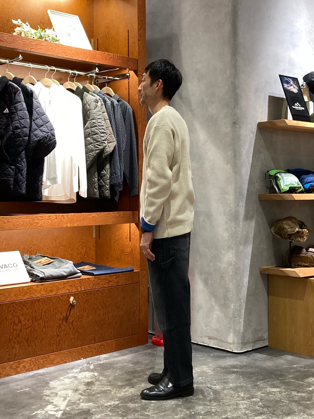 ホワイト系のニット/セーター、ブラック系のデニムパンツを着用したメンズの秋コーディネートの2枚目の写真