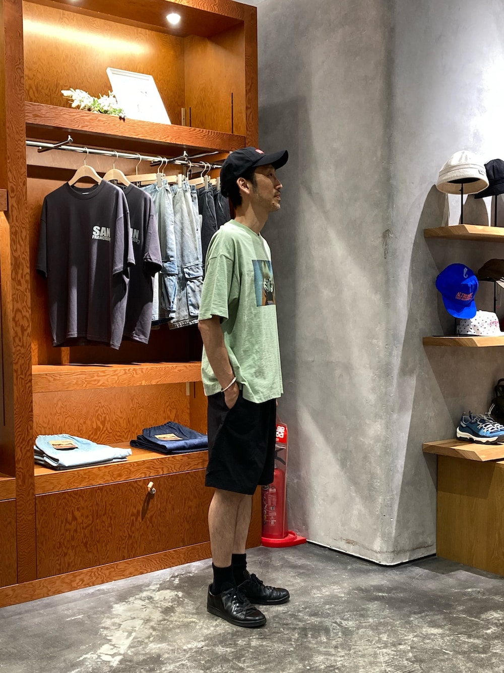 グリーン系のTシャツ/カットソー、ブラック系のその他パンツ、ブラック系のキャップを着用したメンズの夏コーディネートの2枚目の写真