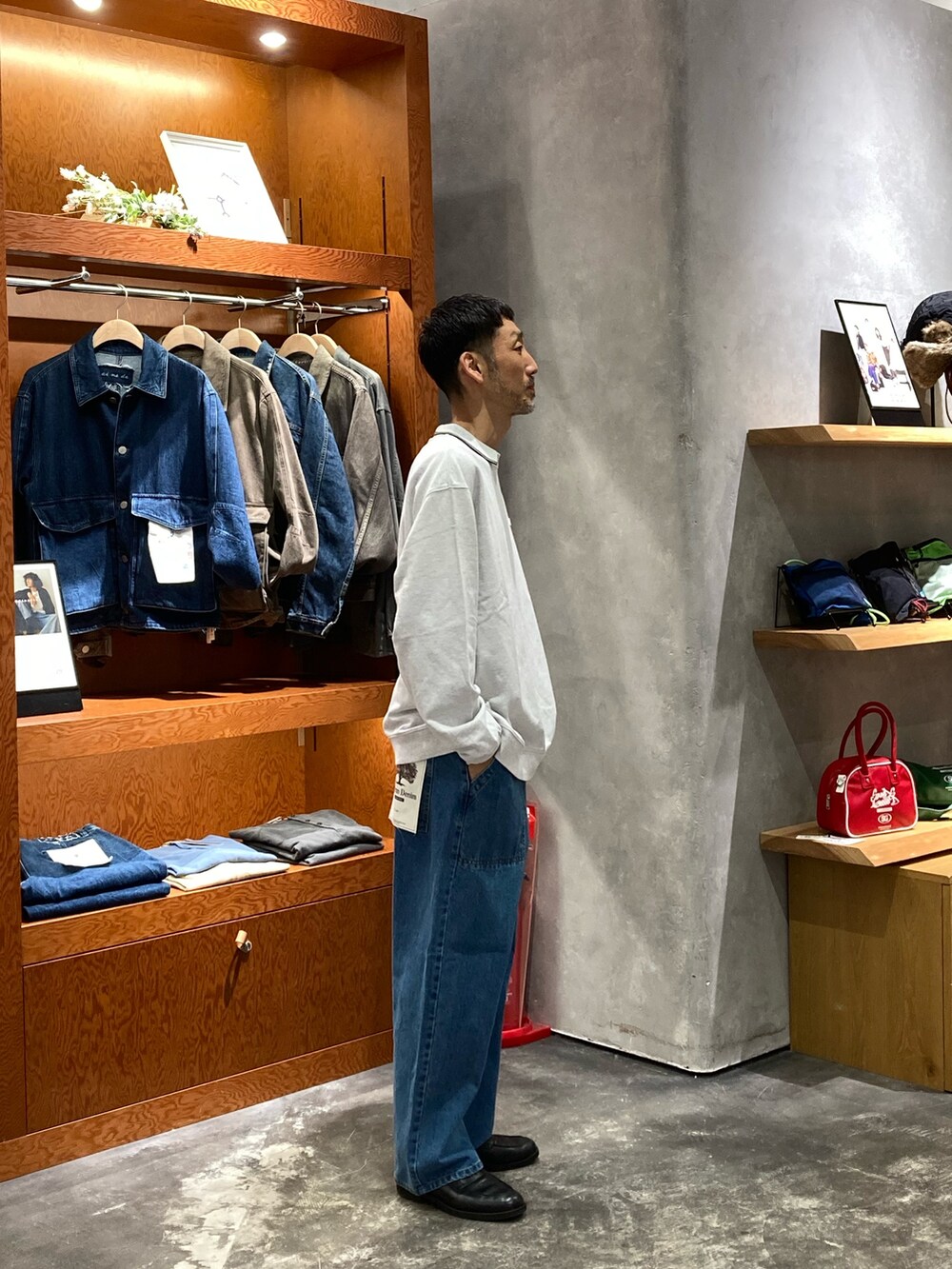 グレー系のスウェット、ブルー系のデニムパンツを着用したメンズの秋コーディネートの2枚目の写真