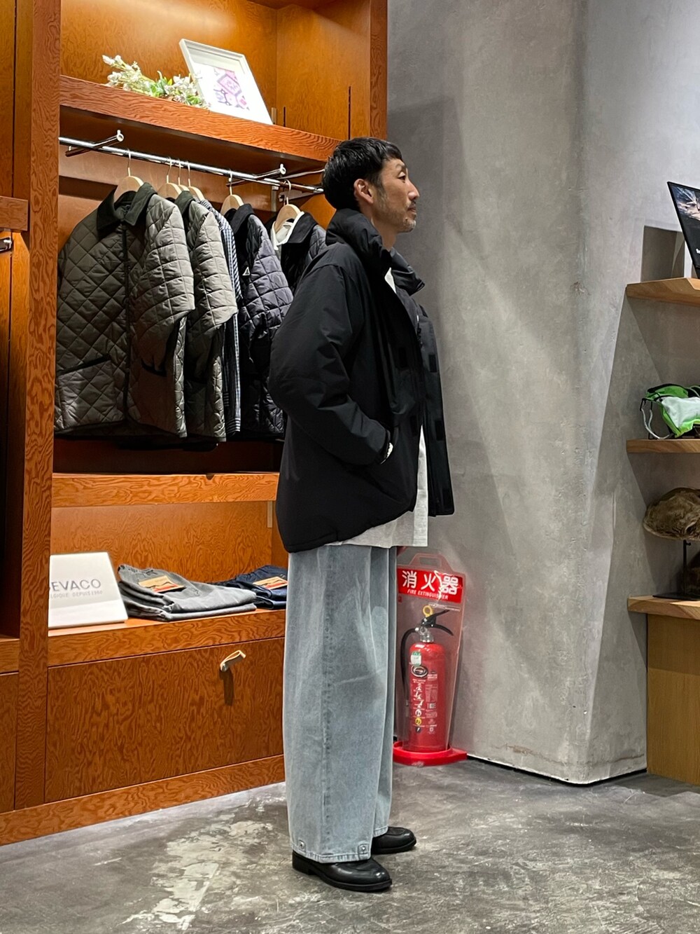 ホワイト系のTシャツ/カットソー、ブルー系のデニムパンツ、ブラック系のダウンジャケット/コートを着用したメンズの秋コーディネートの2枚目の写真