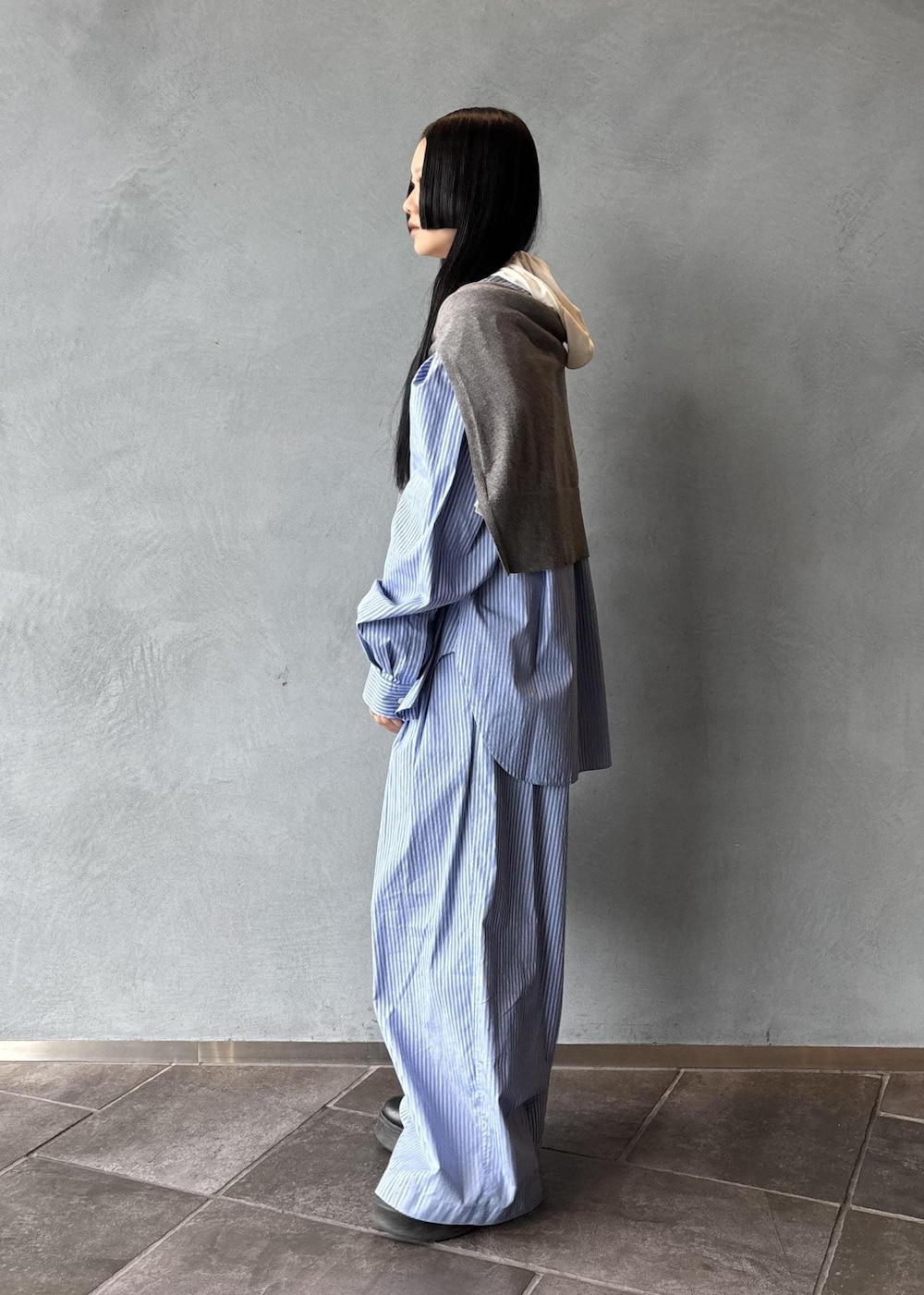 ブラック系のサンダル、グレー系のニット/セーター、ブラック系のハンドバッグを着用したレディースの秋コーディネートの4枚目の写真