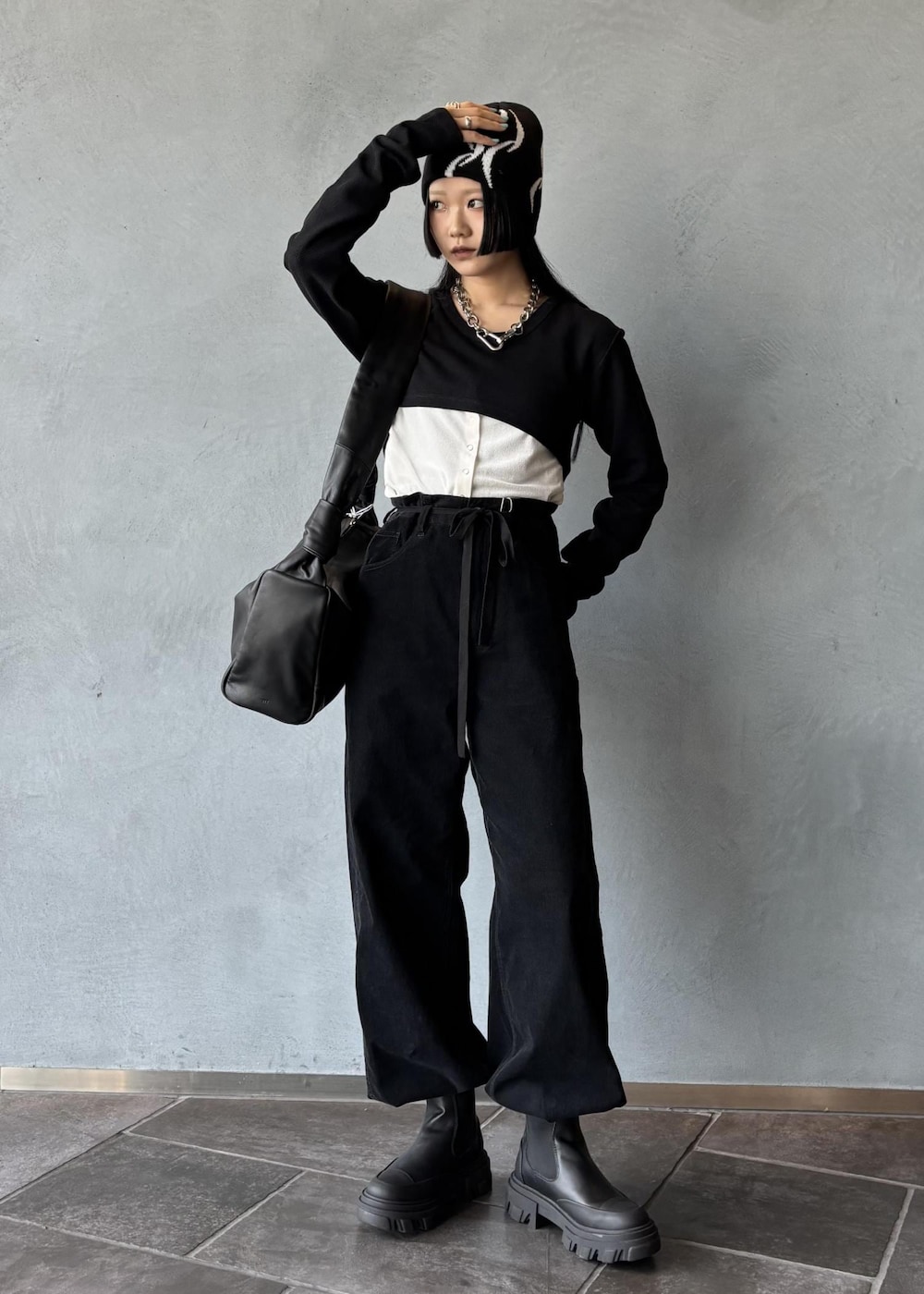 ブラック系のワンピース、ホワイト系のカーディガン/ボレロ、ブラック系のその他パンツを着用したレディースの秋コーディネートの3枚目の写真