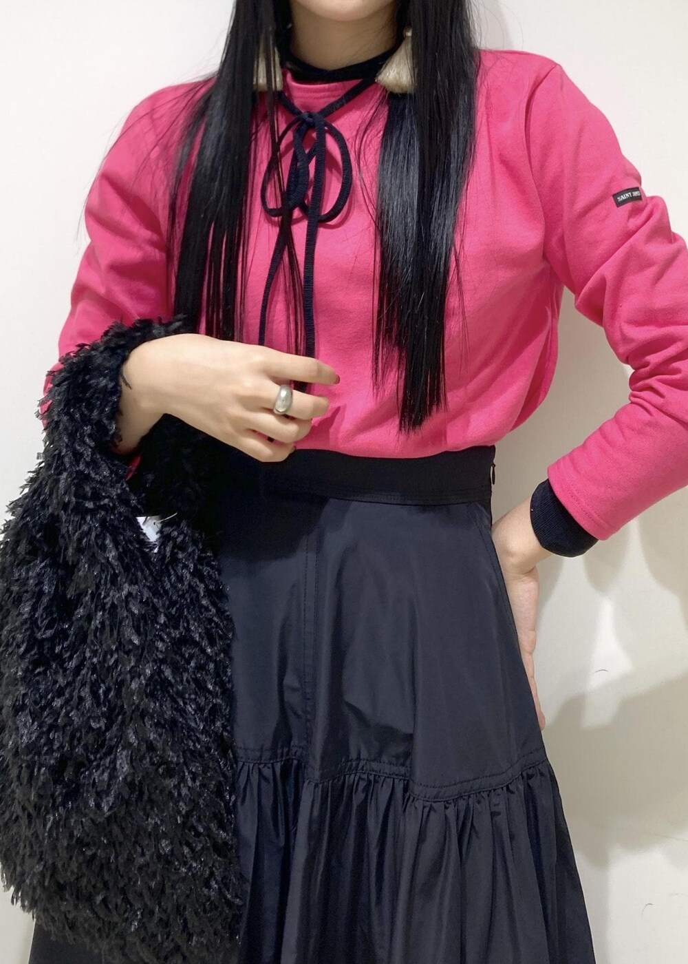 ブラック系のブーツ、ブラック系のスカート、ブラック系のハンドバッグを着用したレディースの秋コーディネートの6枚目の写真