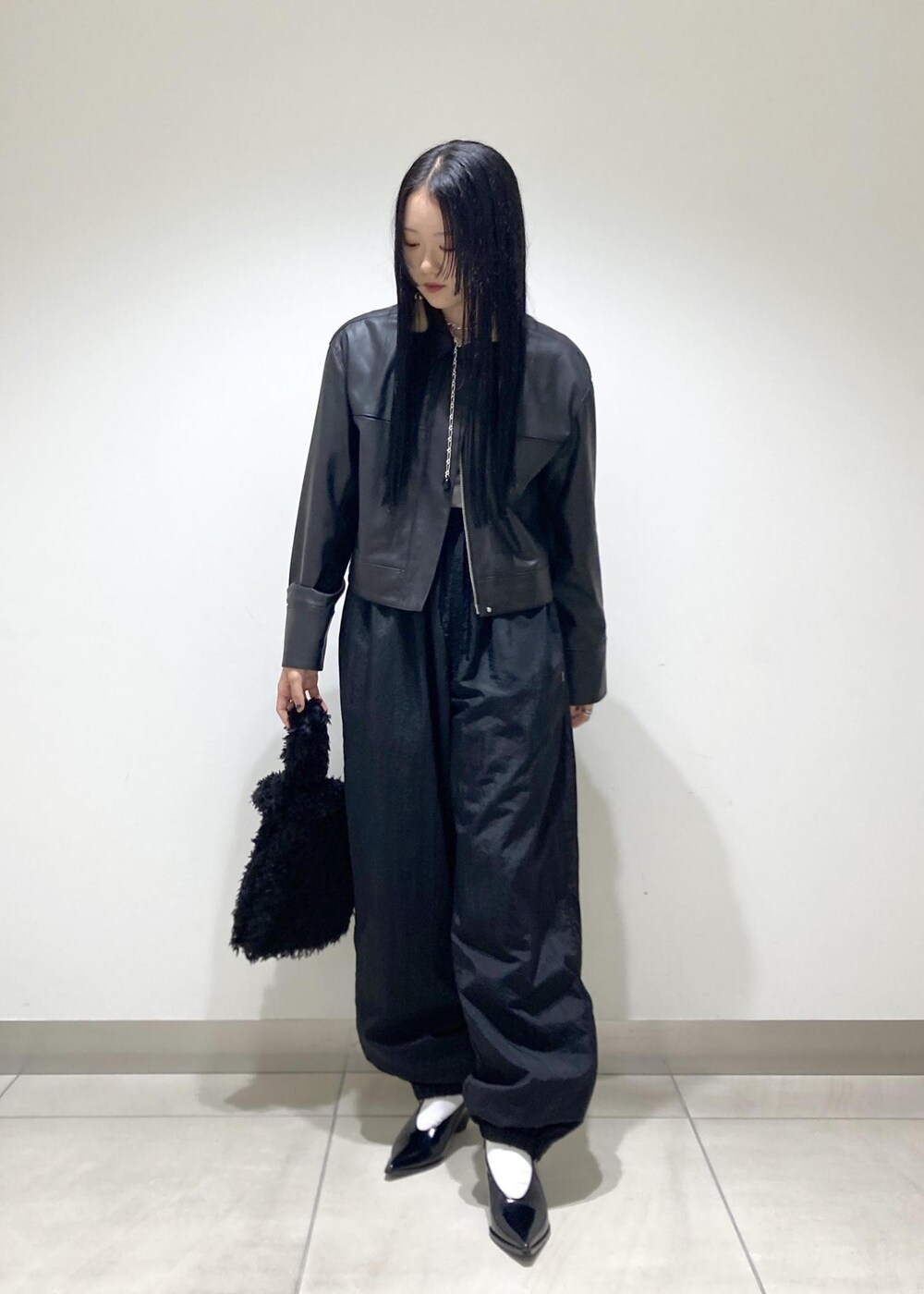 ブラック系のブルゾン、ブラック系のパンプス、ブラック系のハンドバッグを着用したレディースの秋コーディネートの2枚目の写真
