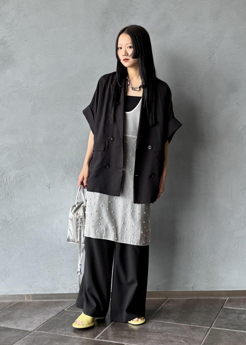 シルバー系のボストンバッグ、ブラック系のその他アウター、ブラック系のスラックスを着用したレディースの春コーディネートの3枚目の写真