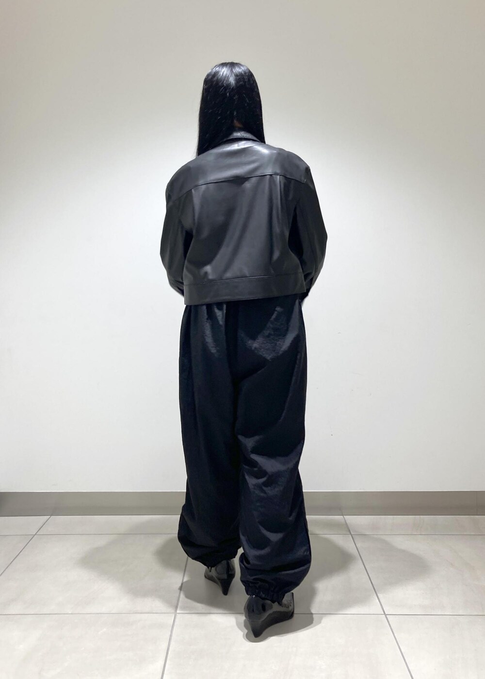 ブラック系のブルゾン、ブラック系のパンプス、ブラック系のハンドバッグを着用したレディースの秋コーディネートの5枚目の写真