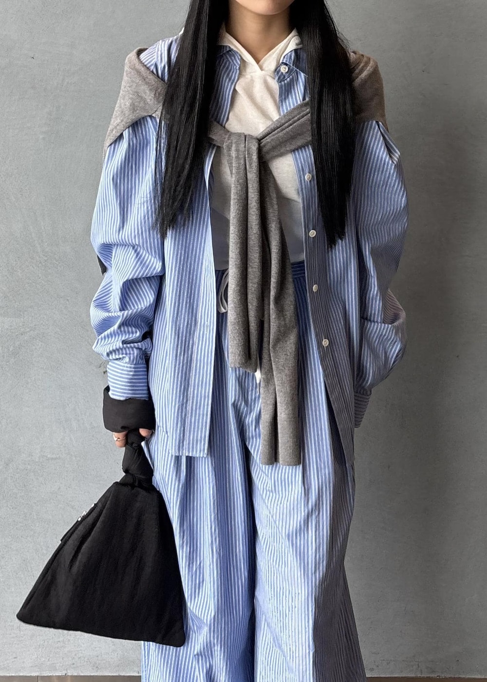 ブラック系のサンダル、グレー系のニット/セーター、ブラック系のハンドバッグを着用したレディースの秋コーディネートの7枚目の写真