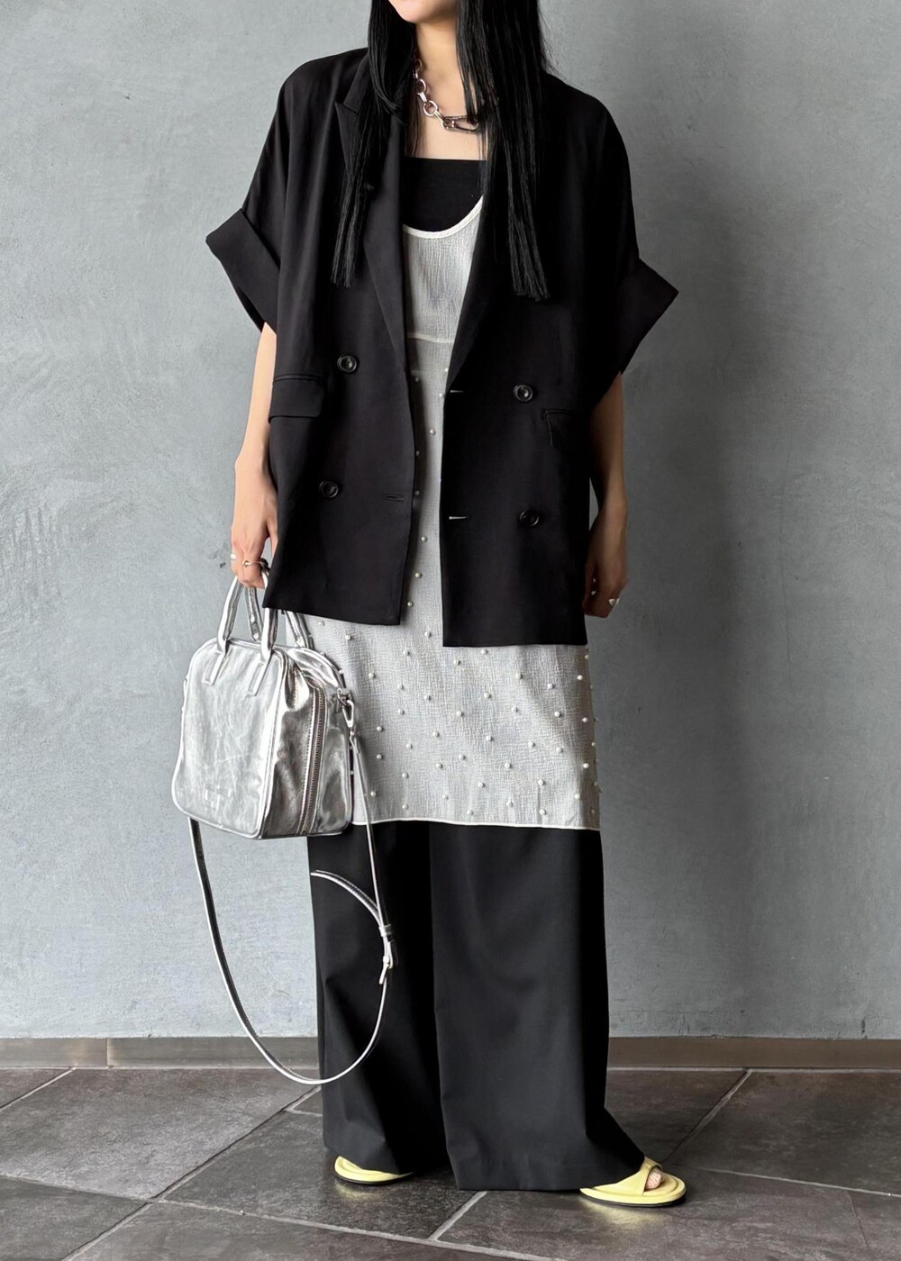 シルバー系のボストンバッグ、ブラック系のその他アウター、ブラック系のスラックスを着用したレディースの春コーディネートの6枚目の写真