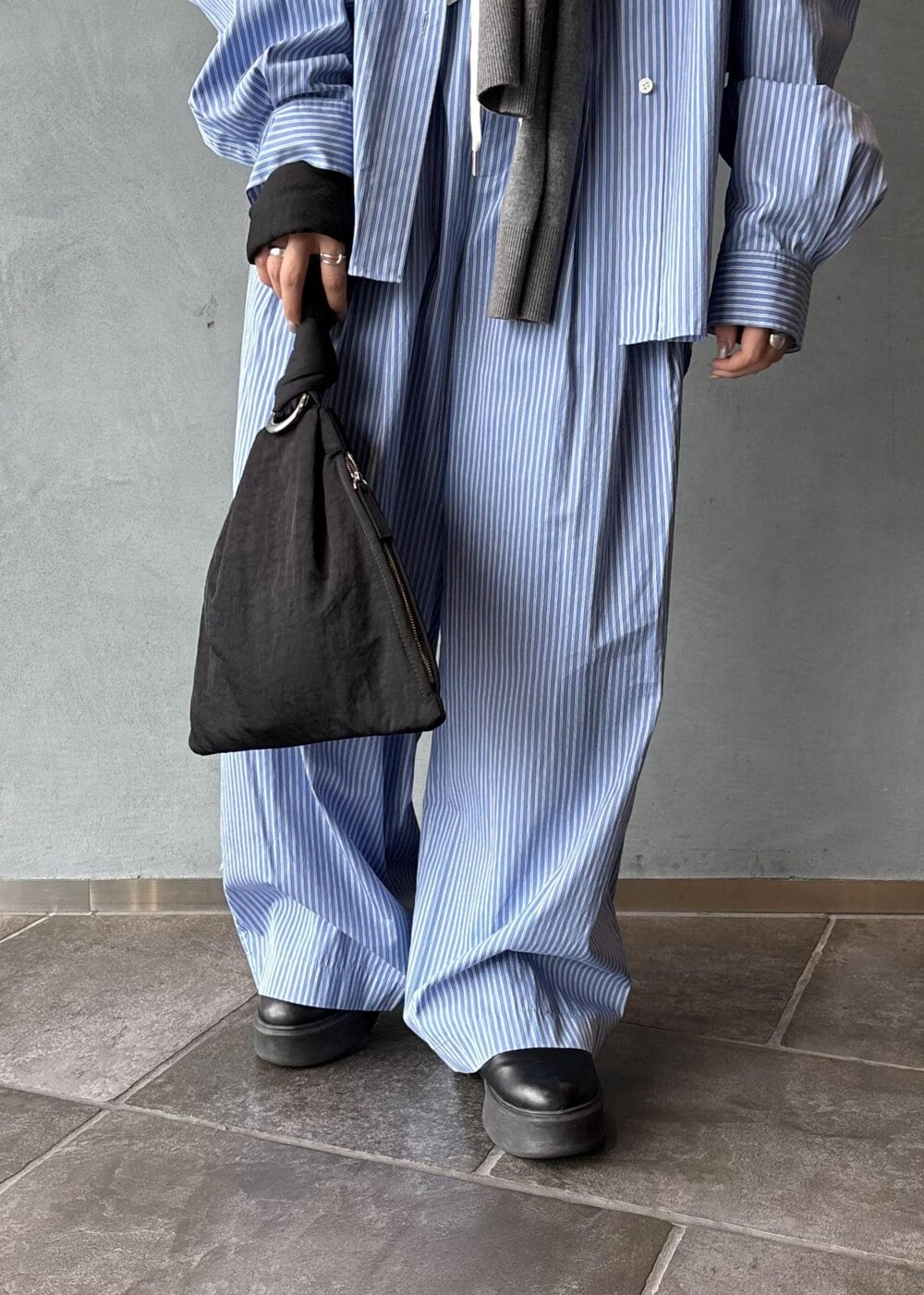 ブラック系のサンダル、グレー系のニット/セーター、ブラック系のハンドバッグを着用したレディースの秋コーディネートの8枚目の写真