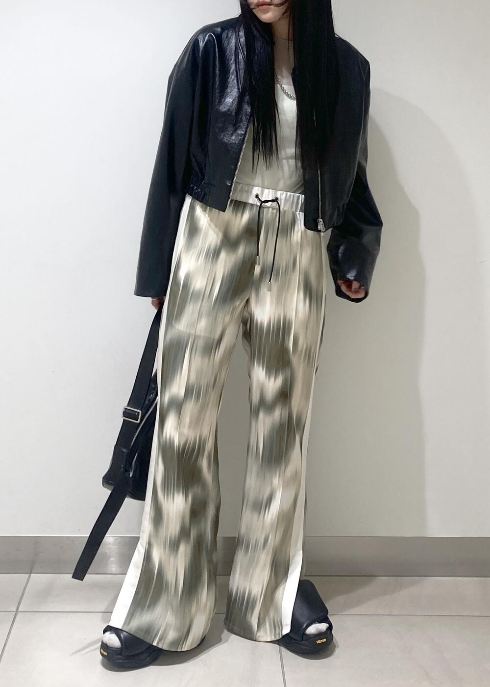 ベージュ系のその他パンツ、ブラック系のサンダル、ブラック系のブルゾンを着用したレディースの春コーディネートの4枚目の写真