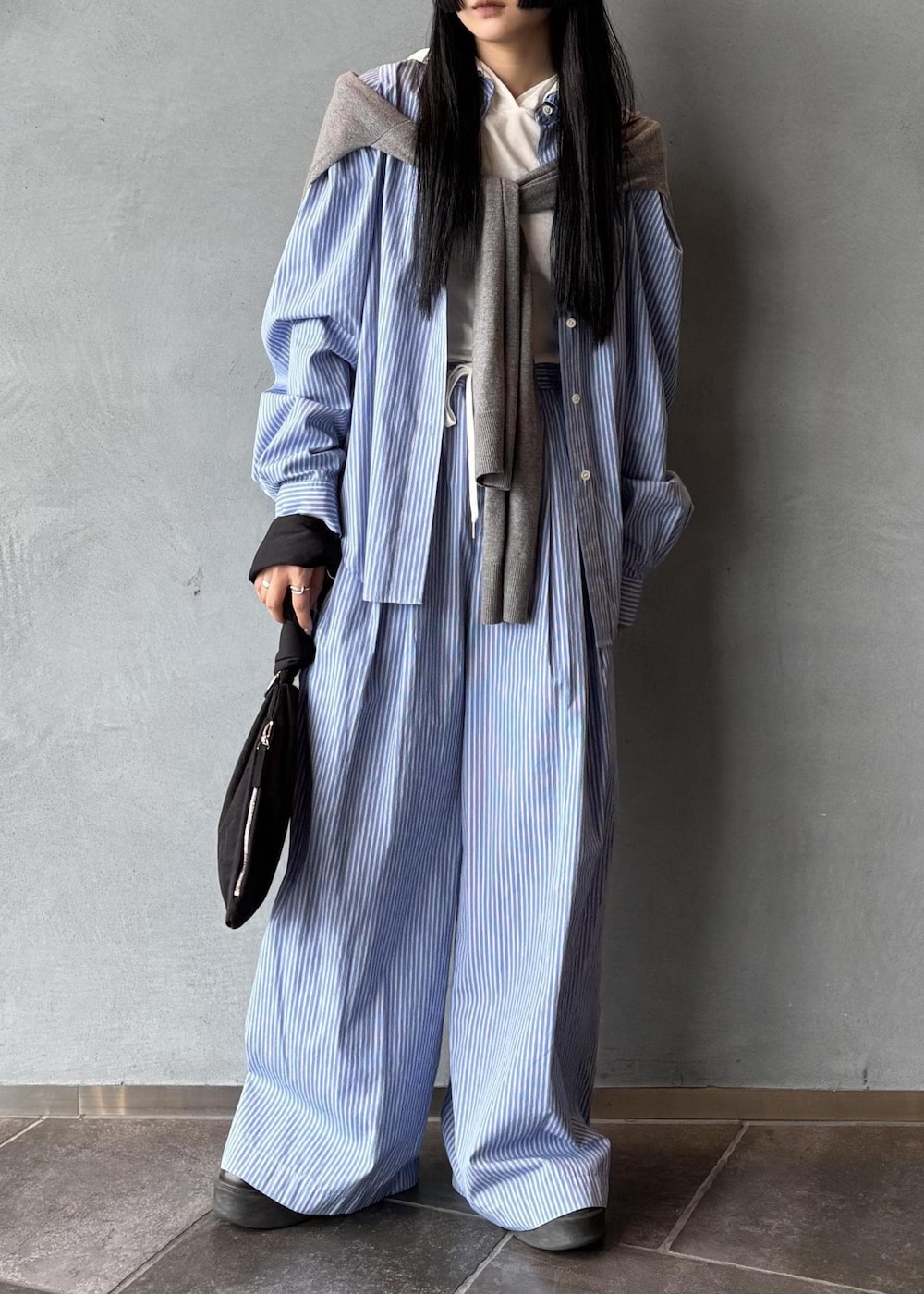 ブラック系のサンダル、グレー系のニット/セーター、ブラック系のハンドバッグを着用したレディースの秋コーディネートの3枚目の写真