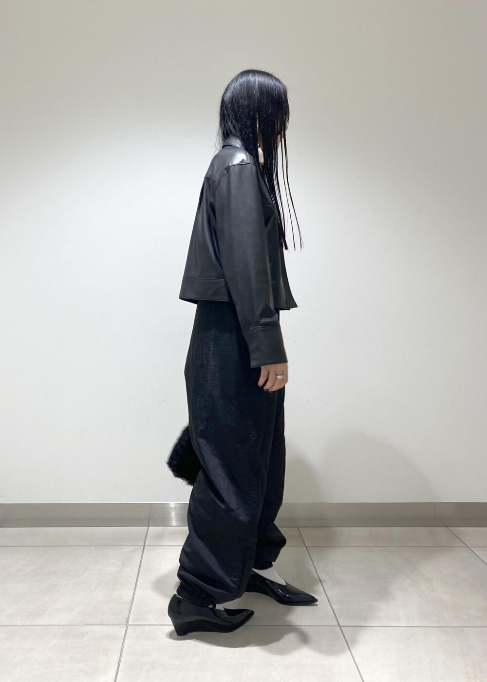 ブラック系のブルゾン、ブラック系のパンプス、ブラック系のハンドバッグを着用したレディースの秋コーディネートの4枚目の写真