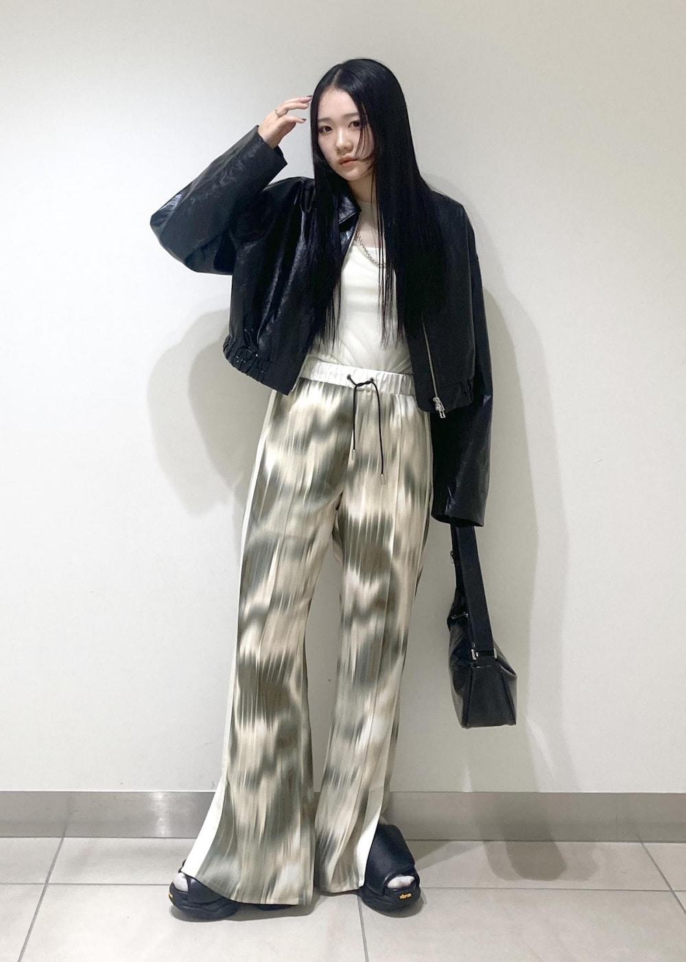 ベージュ系のその他パンツ、ブラック系のサンダル、ブラック系のブルゾンを着用したレディースの春コーディネートの2枚目の写真
