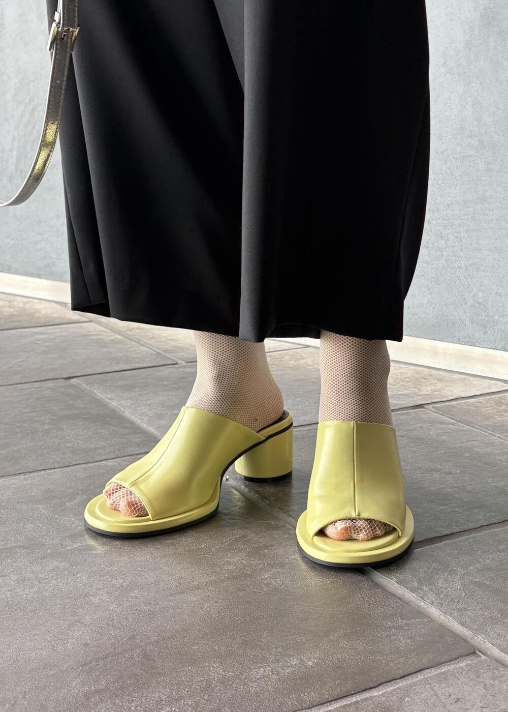 シルバー系のボストンバッグ、ブラック系のその他アウター、ブラック系のスラックスを着用したレディースの春コーディネートの10枚目の写真