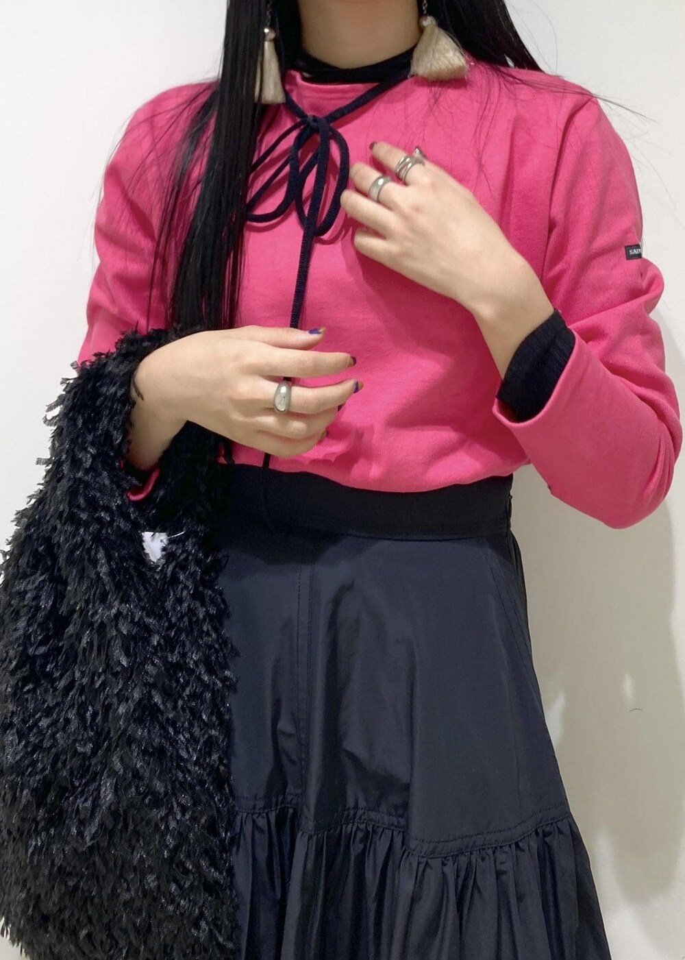 ブラック系のブーツ、ブラック系のスカート、ブラック系のハンドバッグを着用したレディースの秋コーディネートの7枚目の写真