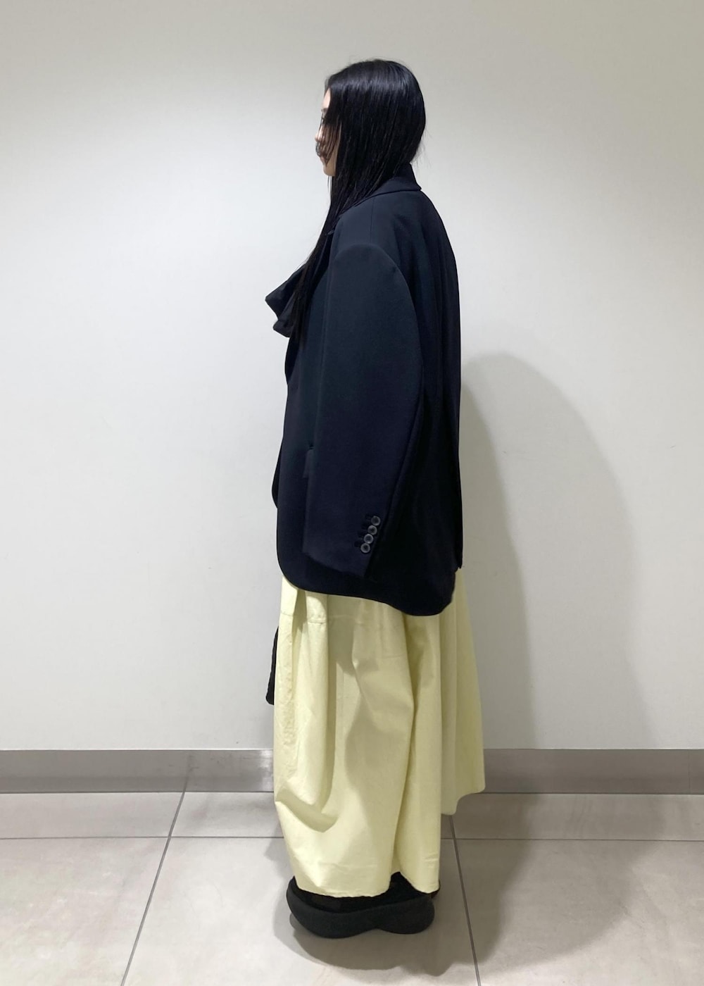 ブラック系のハンドバッグ、イエロー系のワンピース、ブラック系のワンピースを着用したレディースの冬コーディネートの3枚目の写真