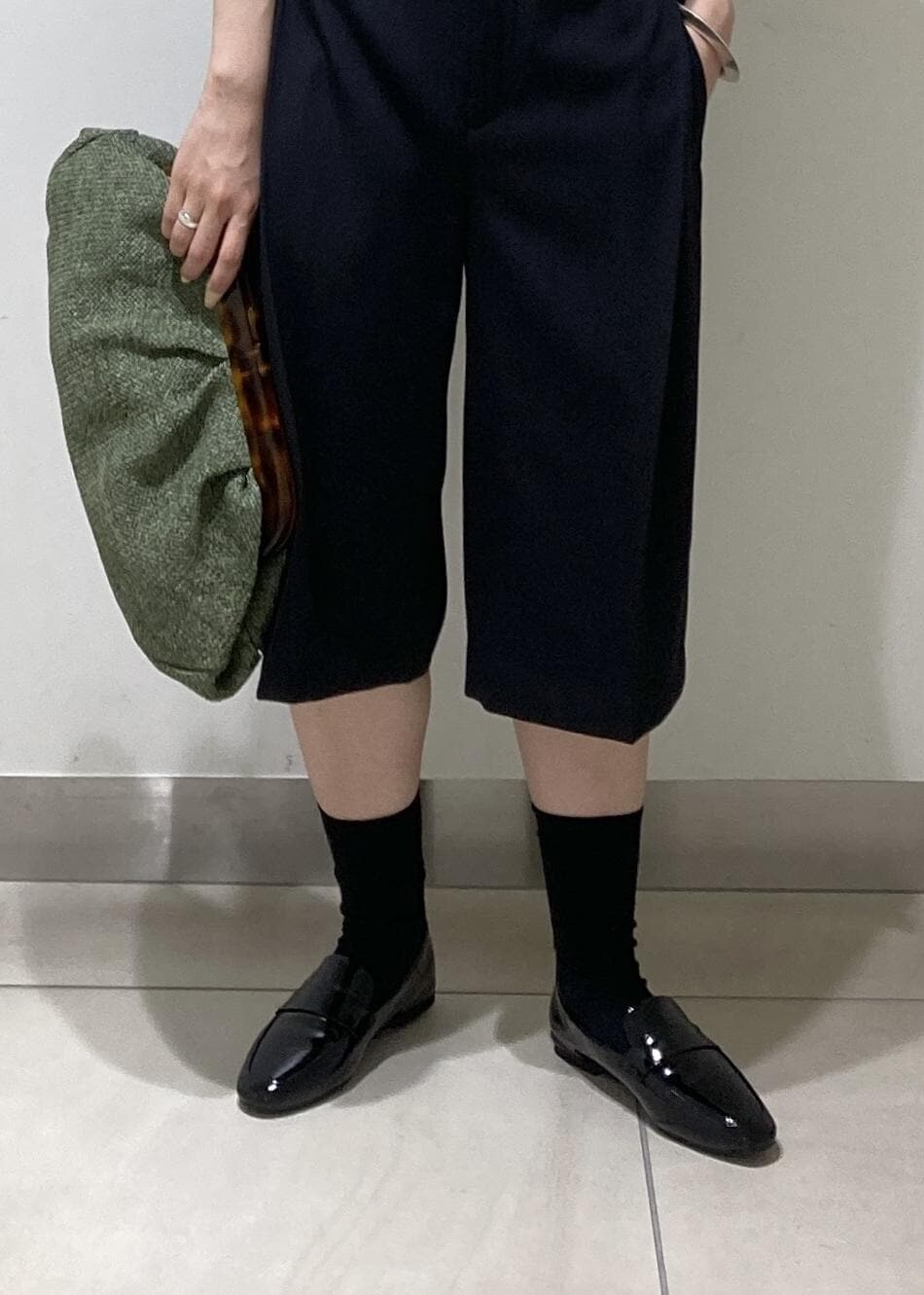 ブラック系のレインシューズ、ホワイト系のタンクトップ、ブラック系のベストを着用したレディースの夏コーディネートの7枚目の写真