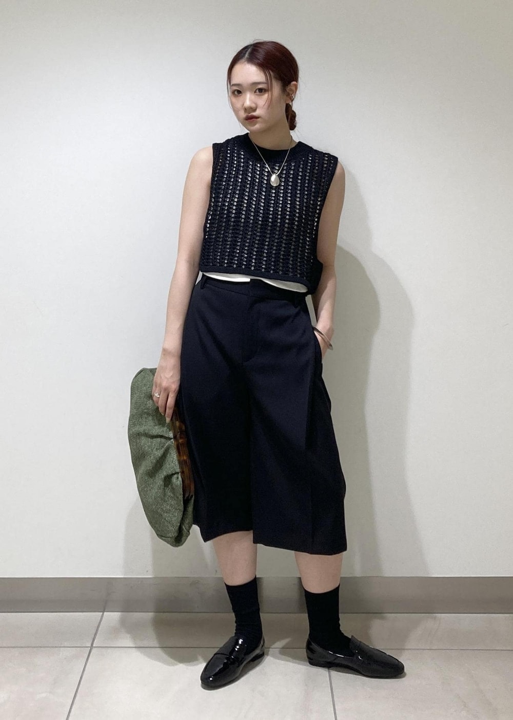 ブラック系のレインシューズ、ホワイト系のタンクトップ、ブラック系のベストを着用したレディースの夏コーディネートの2枚目の写真