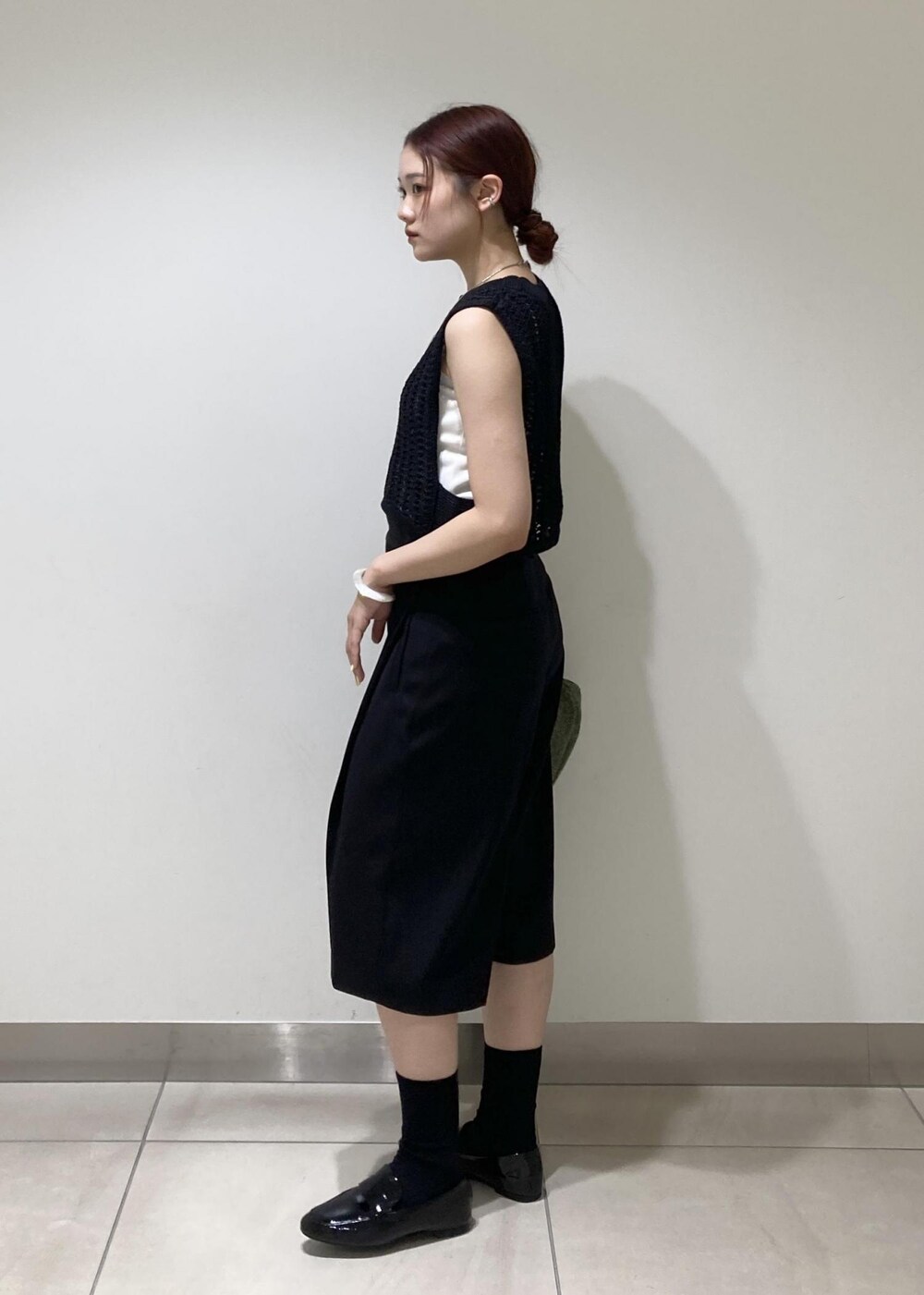 ブラック系のレインシューズ、ホワイト系のタンクトップ、ブラック系のベストを着用したレディースの夏コーディネートの4枚目の写真