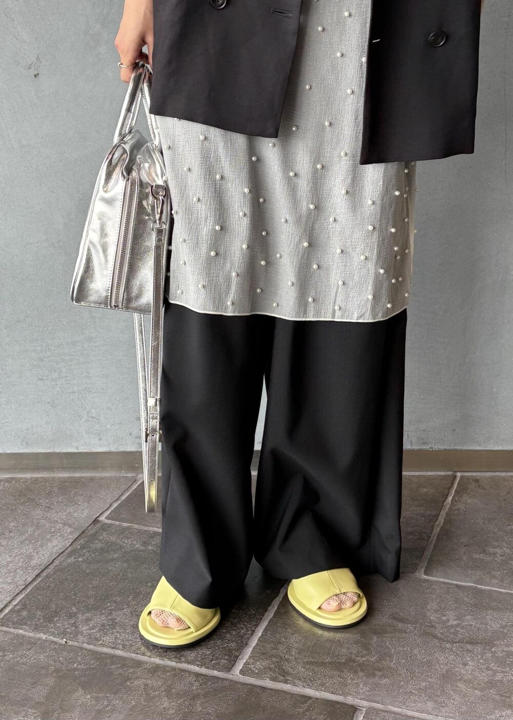 シルバー系のボストンバッグ、ブラック系のその他アウター、ブラック系のスラックスを着用したレディースの春コーディネートの8枚目の写真