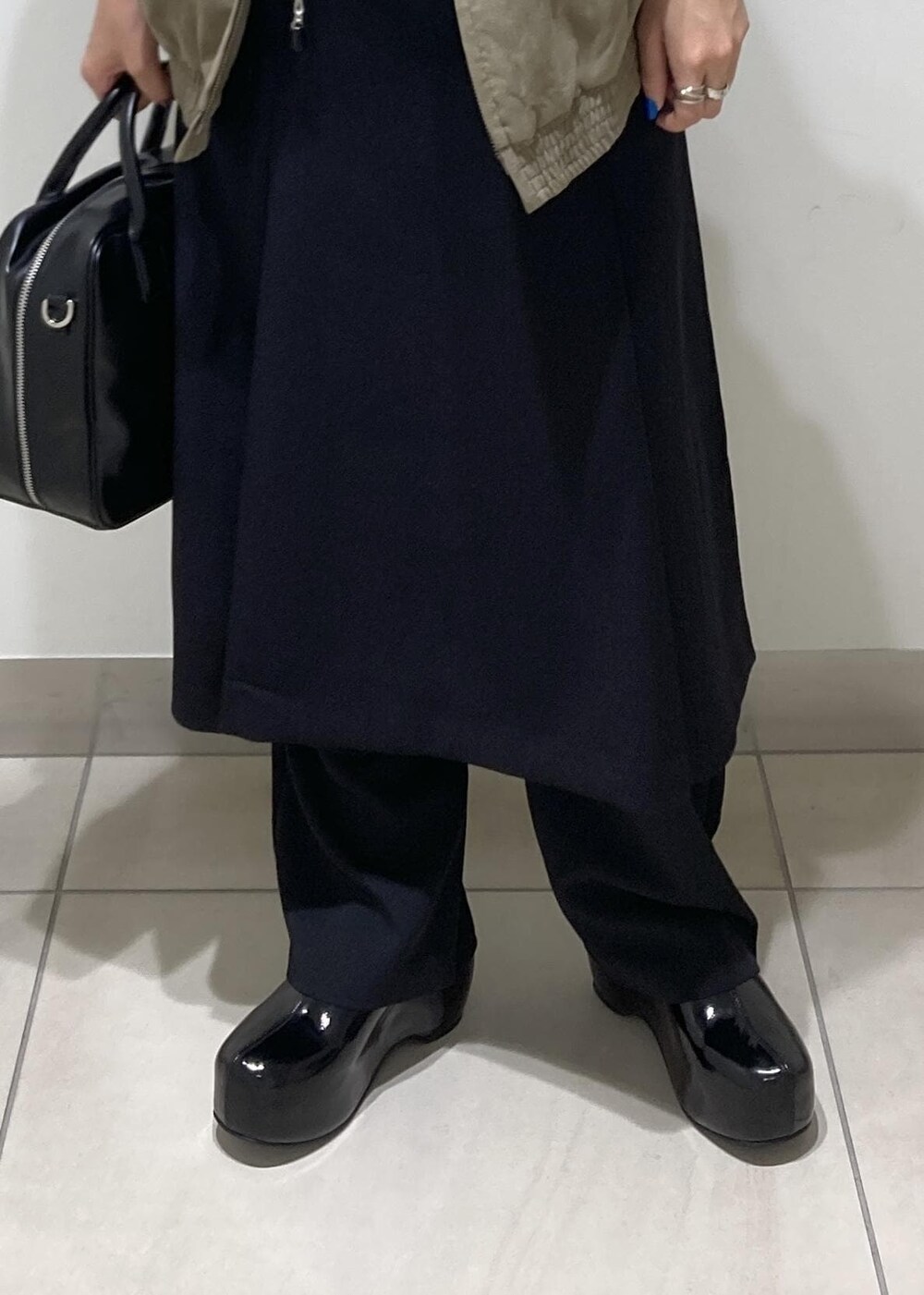 ブラック系のその他パンツ、ホワイト系のTシャツ/カットソー、ブラック系のスカートを着用したレディースの秋コーディネートの7枚目の写真