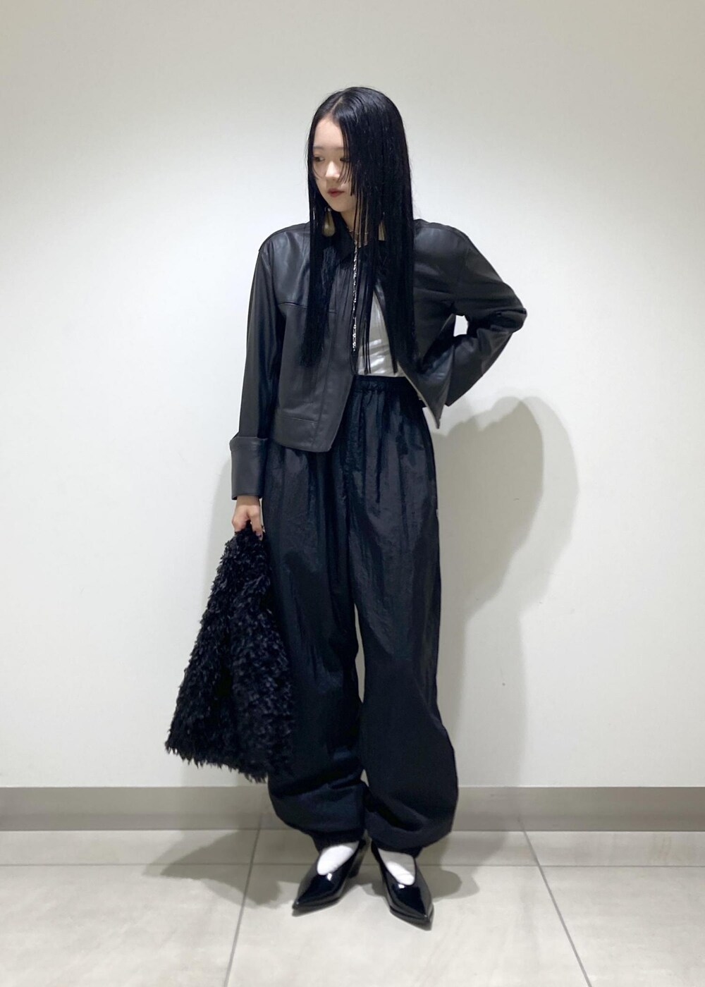 ブラック系のブルゾン、ブラック系のパンプス、ブラック系のハンドバッグを着用したレディースの秋コーディネートの3枚目の写真