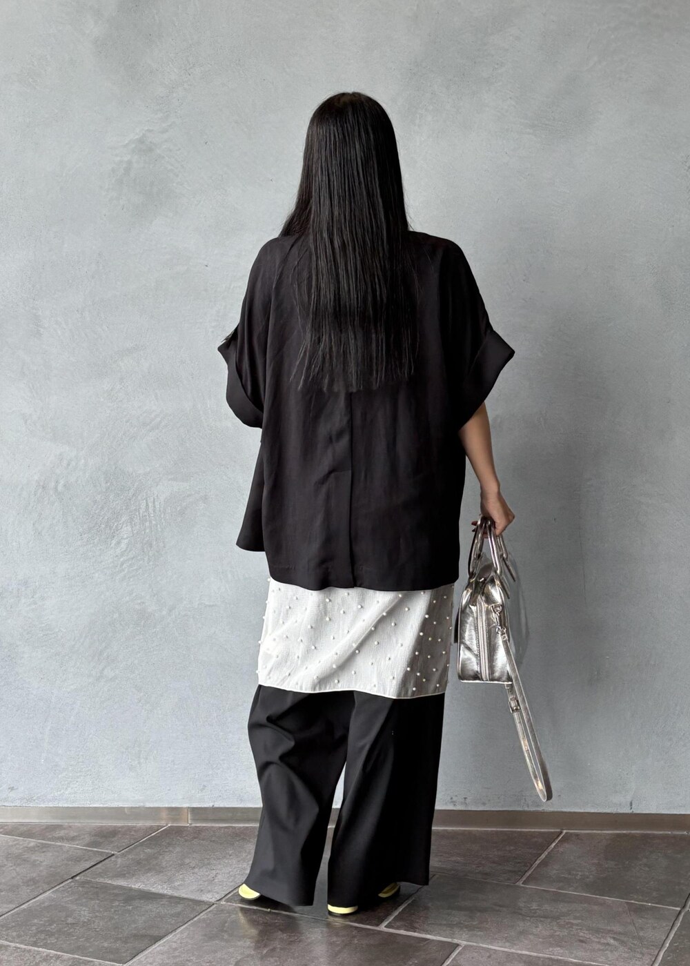 シルバー系のボストンバッグ、ブラック系のその他アウター、ブラック系のスラックスを着用したレディースの春コーディネートの5枚目の写真