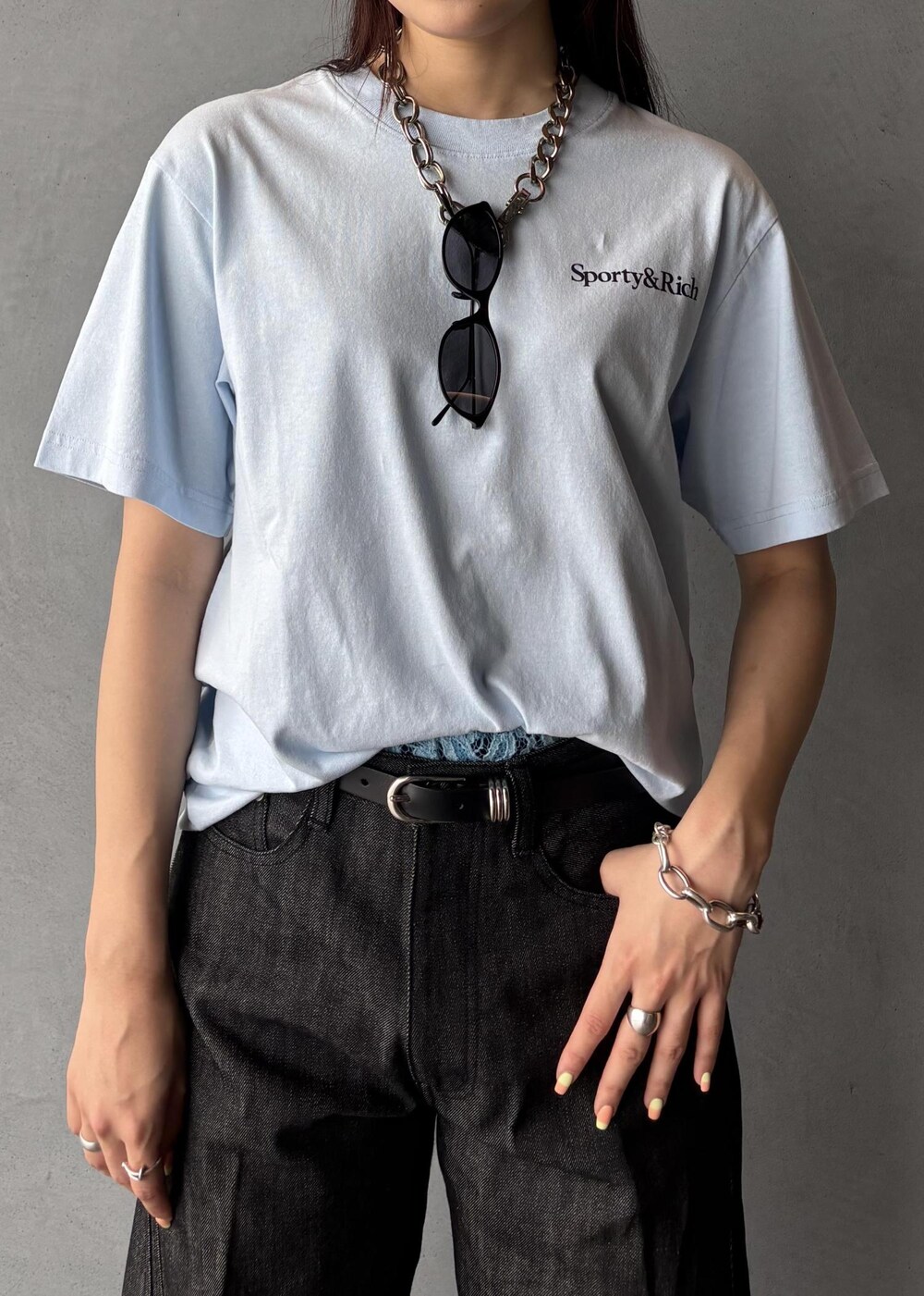 ブラック系のデニムパンツ、ブルー系のTシャツ/カットソー、ブラック系のサングラスを着用したレディースの夏コーディネートの7枚目の写真