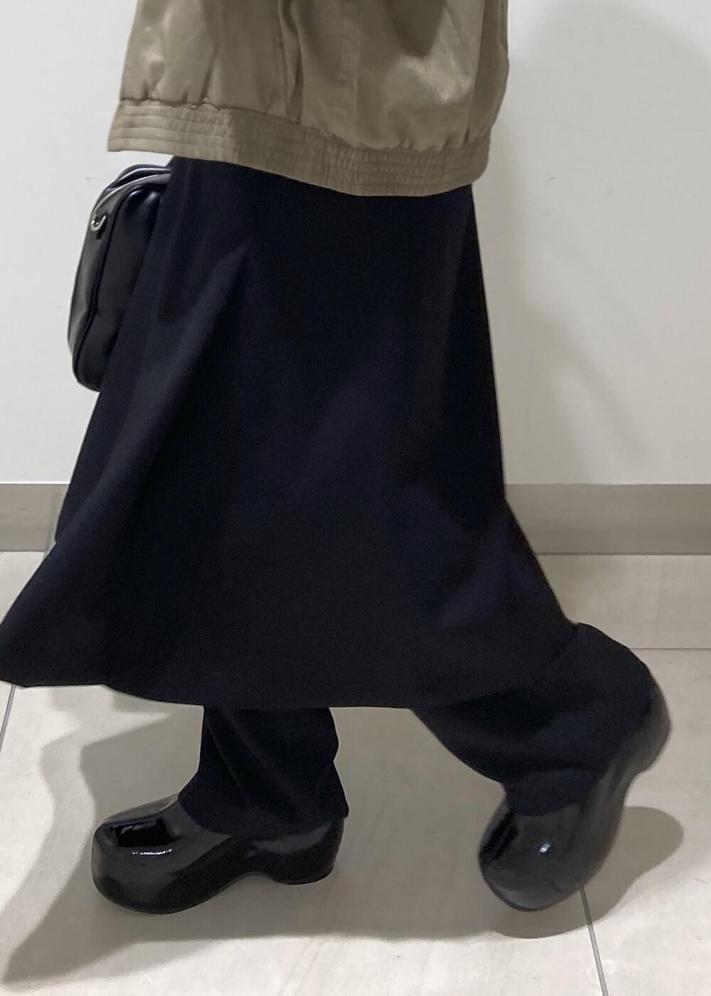 ブラック系のその他パンツ、ホワイト系のTシャツ/カットソー、ブラック系のスカートを着用したレディースの秋コーディネートの8枚目の写真