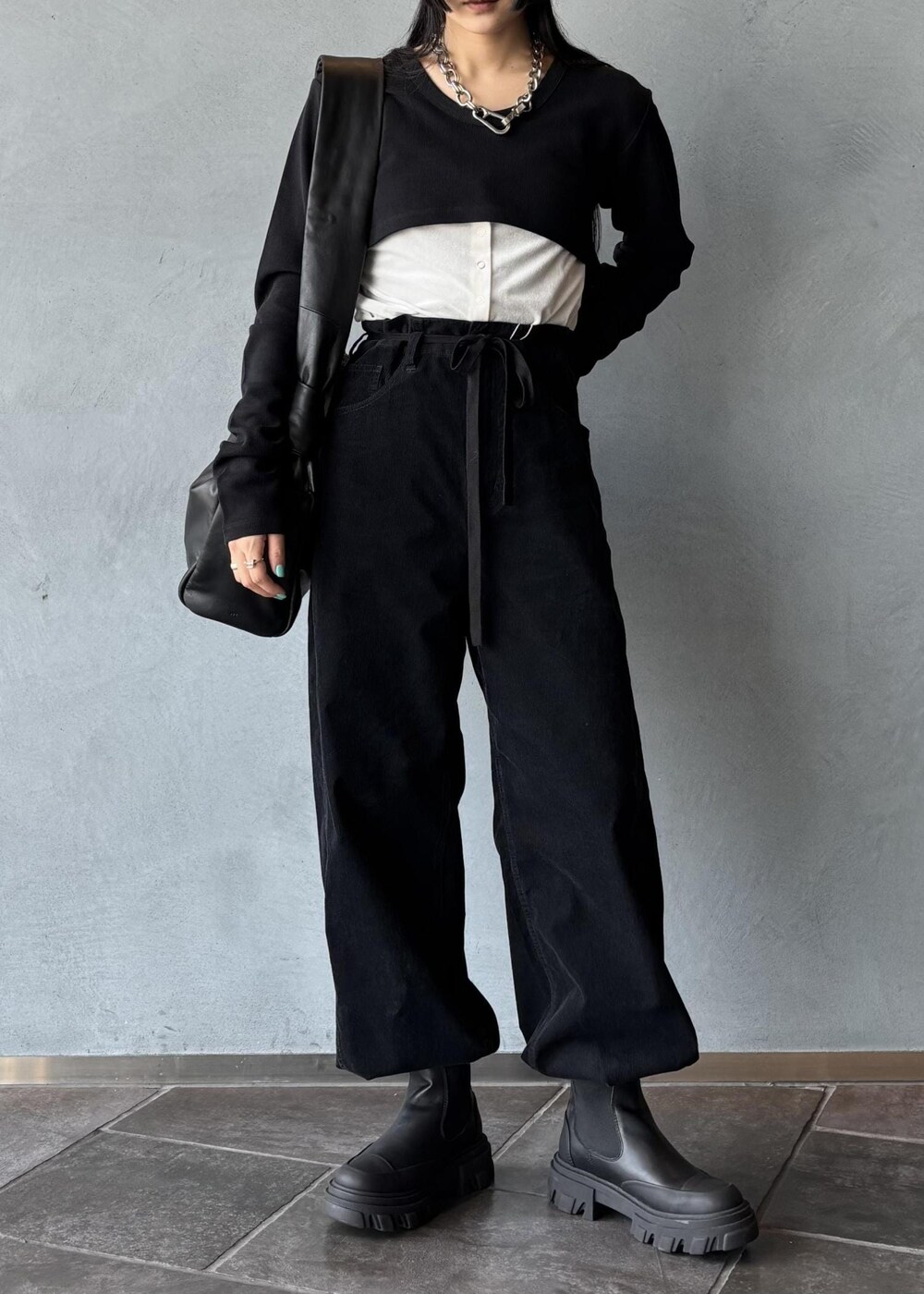 ブラック系のワンピース、ホワイト系のカーディガン/ボレロ、ブラック系のその他パンツを着用したレディースの秋コーディネートの2枚目の写真