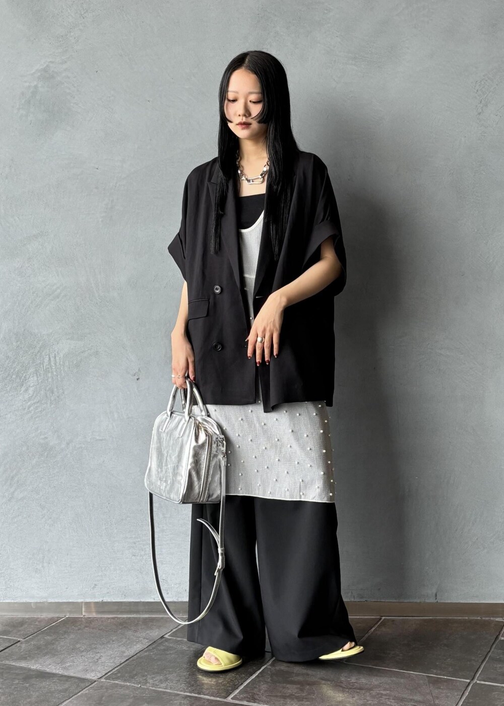 シルバー系のボストンバッグ、ブラック系のその他アウター、ブラック系のスラックスを着用したレディースの春コーディネートの2枚目の写真