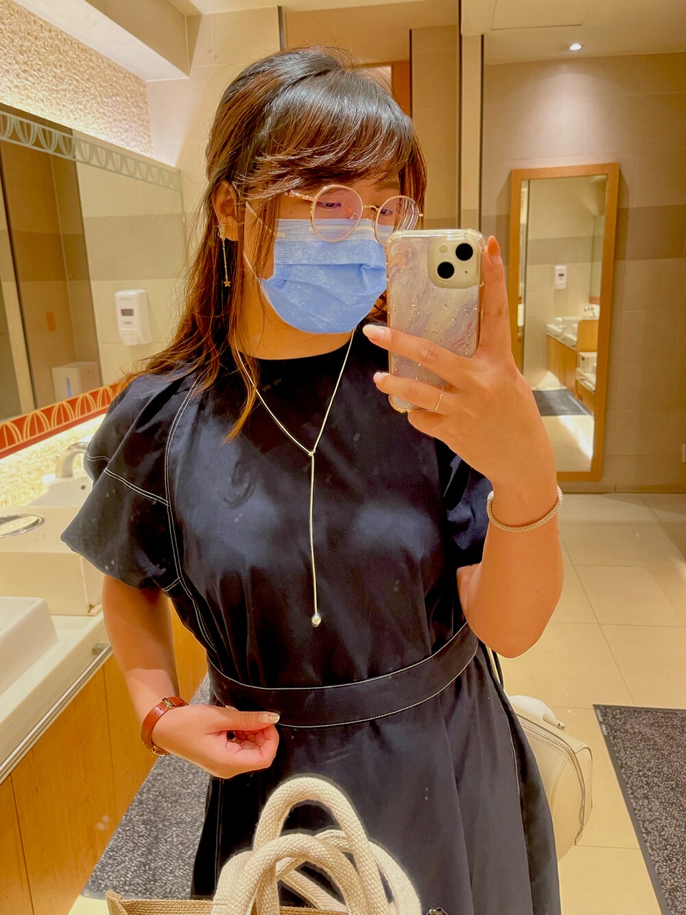 ホワイト系のワンピース、ホワイト系のボストンバッグ、シルバー系のネックレスを着用したレディースの春コーディネートの2枚目の写真