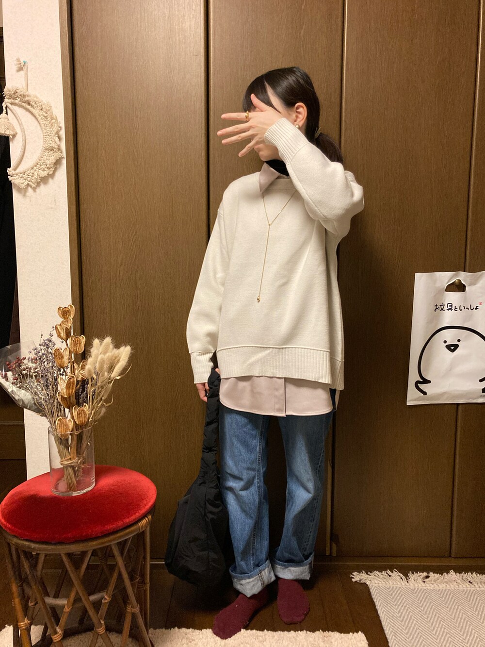 ベージュ系のシャツ/ブラウス、ホワイト系のニット/セーター、ブルー系のデニムパンツを着用したレディースの冬コーディネートの2枚目の写真