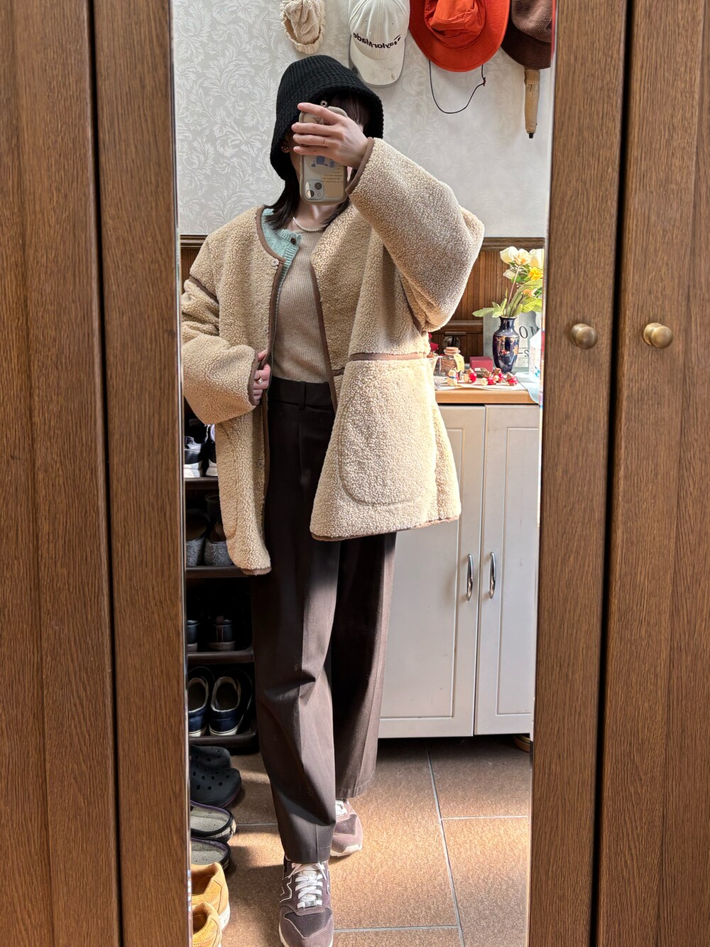 ブラウン系のスラックス、ベージュ系のニット/セーターを着用したレディースの秋コーディネートの2枚目の写真