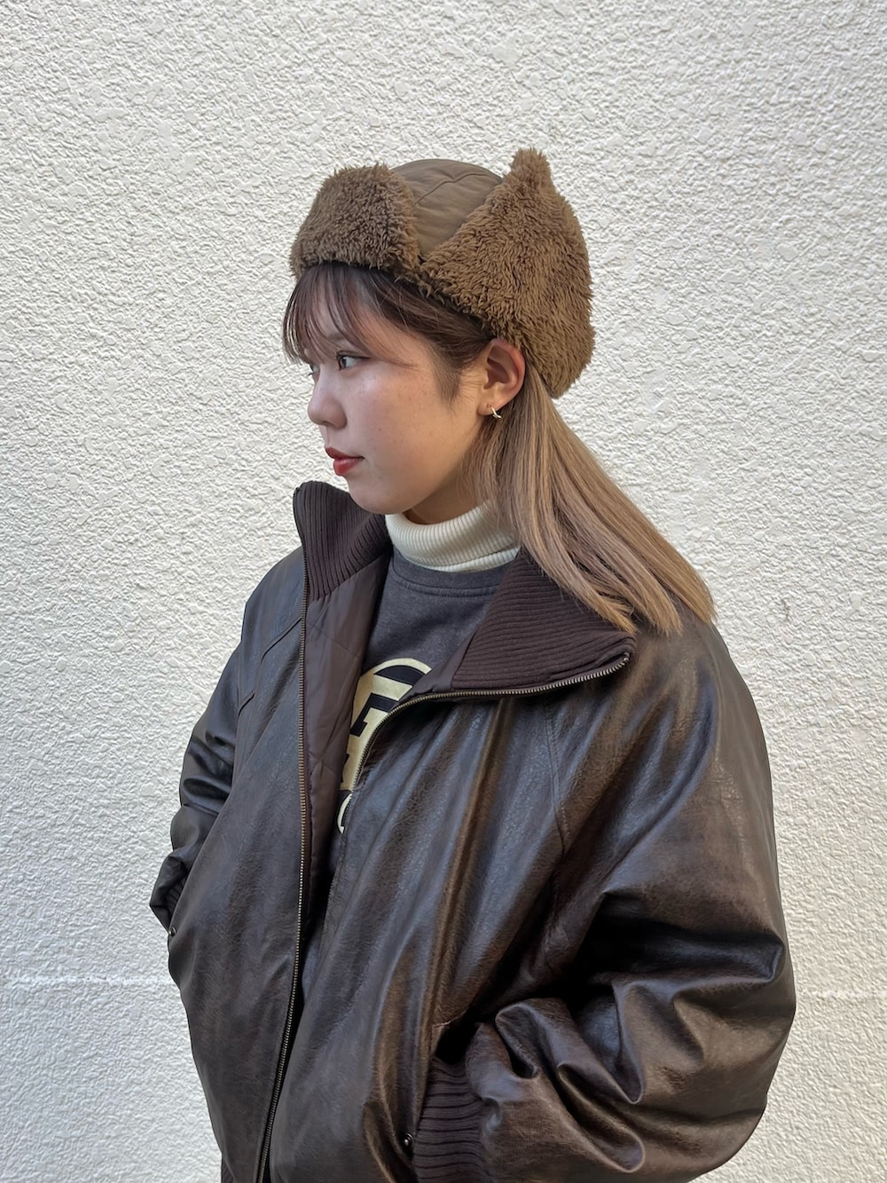 ブラウン系のブルゾン、ベージュ系のハットを着用したレディースの冬コーディネートの2枚目の写真