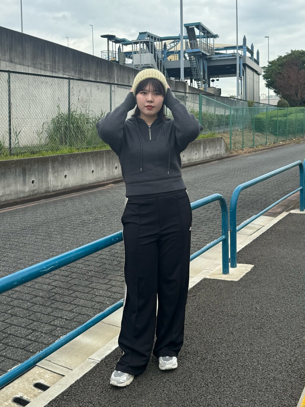 グレー系のニット/セーター、グレー系のスニーカー、グリーン系のニットキャップ/ビーニーを着用したレディースの秋コーディネートの2枚目の写真