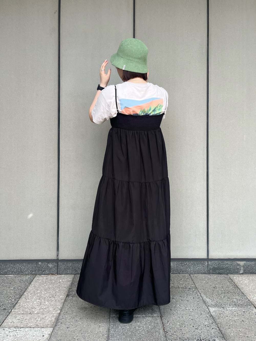 ブラック系のワンピース、グリーン系のハットを着用したレディースの夏コーディネートの2枚目の写真