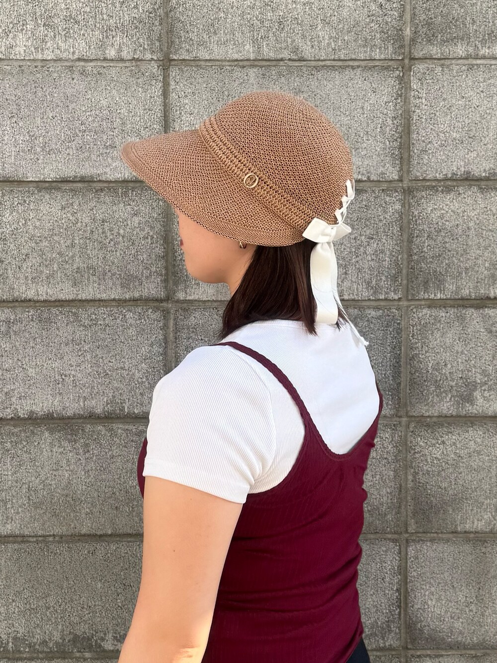 ベージュ系のキャップを着用したレディースの夏コーディネートの2枚目の写真